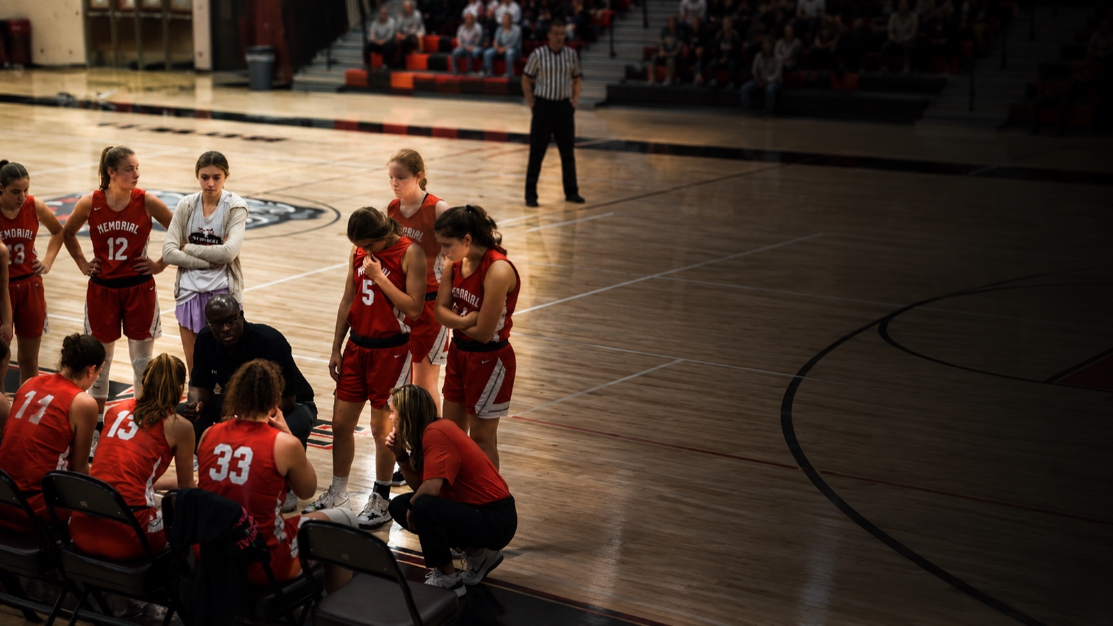 Jyusef Larry, founder and head coach, in a huddle with his team